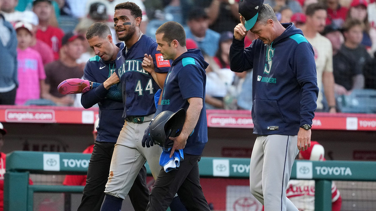 Seattle Mariners center fielder Julio Rodriguez (44) walks off the field with manager Dan Wilson (6) after being hit by a batted ball in the third inning against the Los Angeles Angels at Angel Stadium.