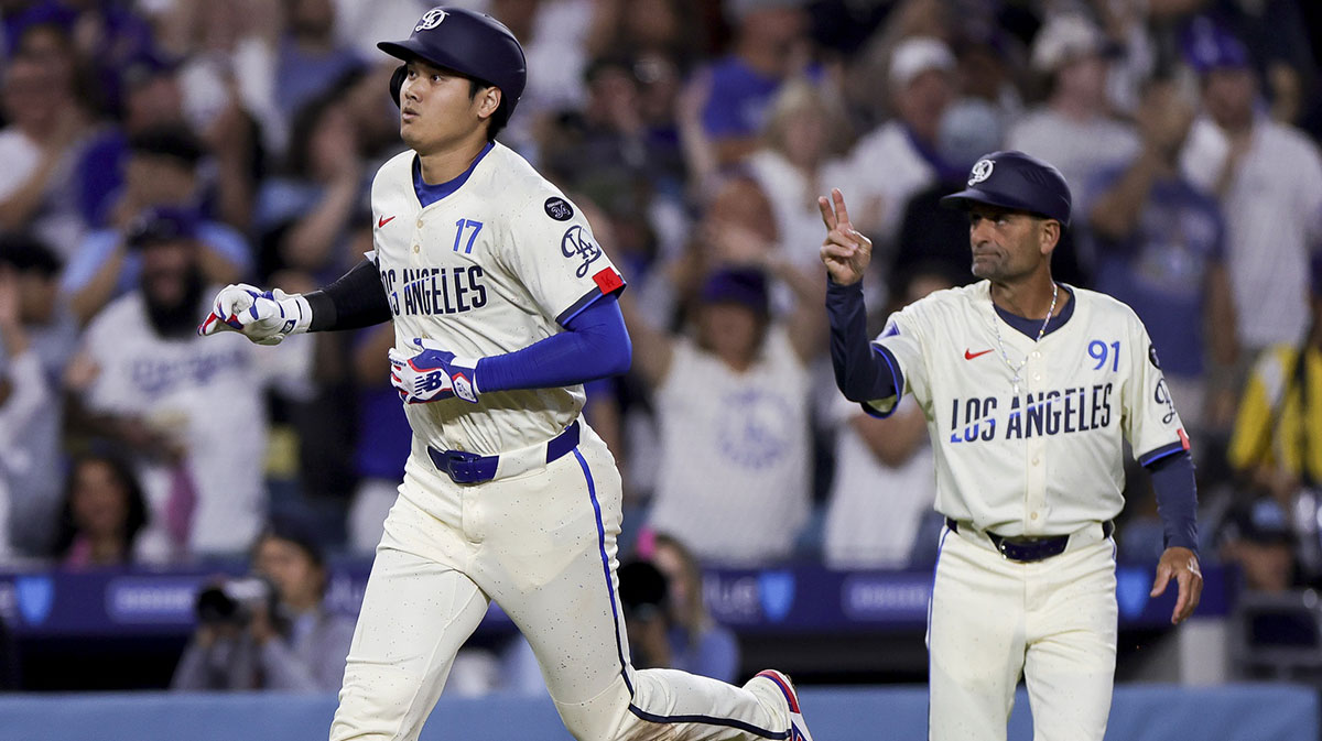 Los Angeles Dodgers designated hitter Shohei Ohtani, left, celebrates with third base coach Dino Ebel after hitting a solo home-run during the sixth inning of a baseball game against the San Francisco Giants at Dodger Stadium.
