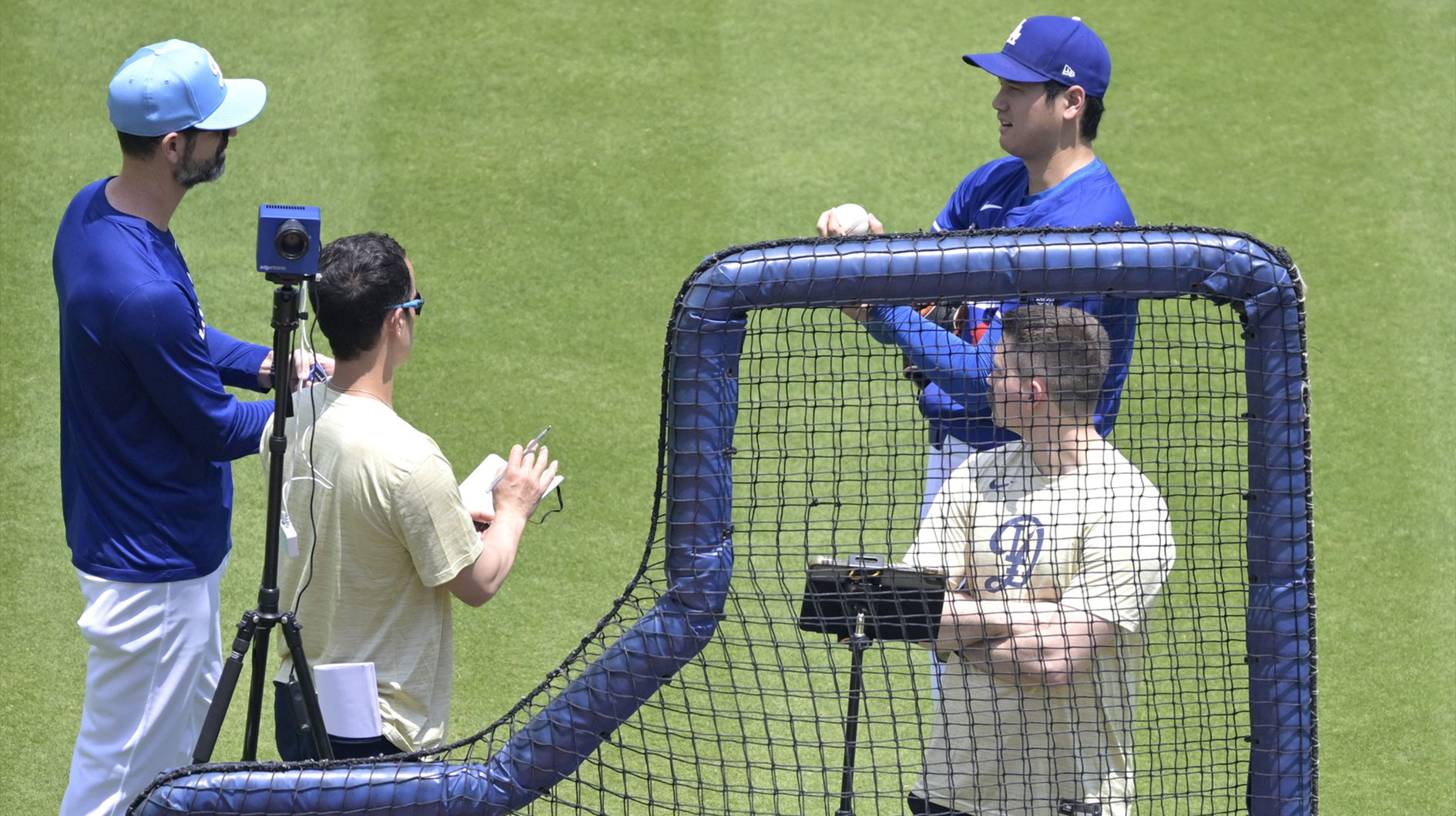 Los Angeles Dodgers Shohei Ohtani (17) talks with Los Angeles Dodgers pitching coach Mark Prior (99), left, and interpreter Will Ireton as he takes a break from throwing live batting practice prior to the game against the New York Yankees at Dodger Stadium.