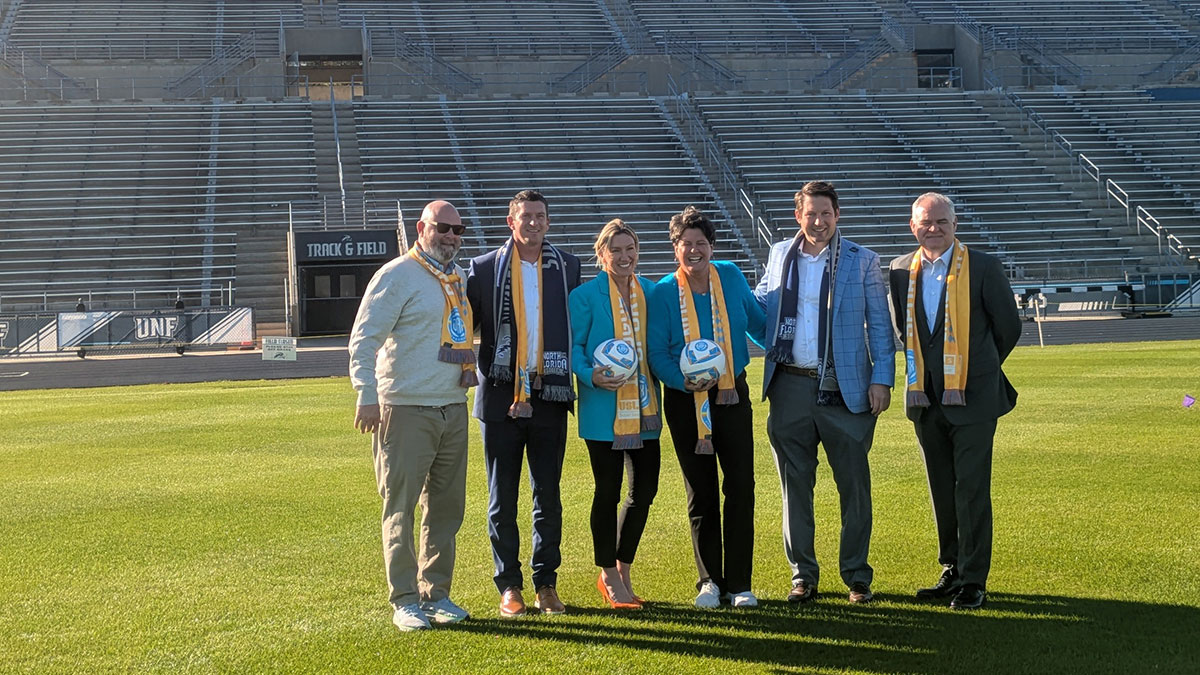 Sporting Jax, UNF and USL Super League administrators stand on the field at the University of North Florida.