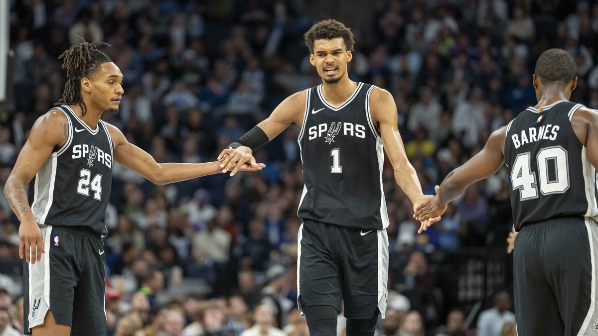 Spurs guard Devin Vassell (24) and San Antonio Spurs forward Harrison Barnes (40) after making a shot against the Minnesota Timberwolves in the second half at Target Center