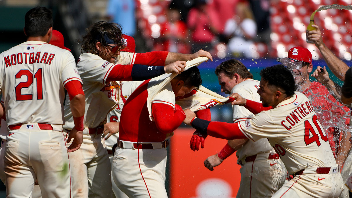 St. Louis Cardinals catcher Yohel Pozo (63) is mobbed by teammates after hitting a walk-off one run single against the Cincinnati Reds during the eleventh inning at Busch Stadium.