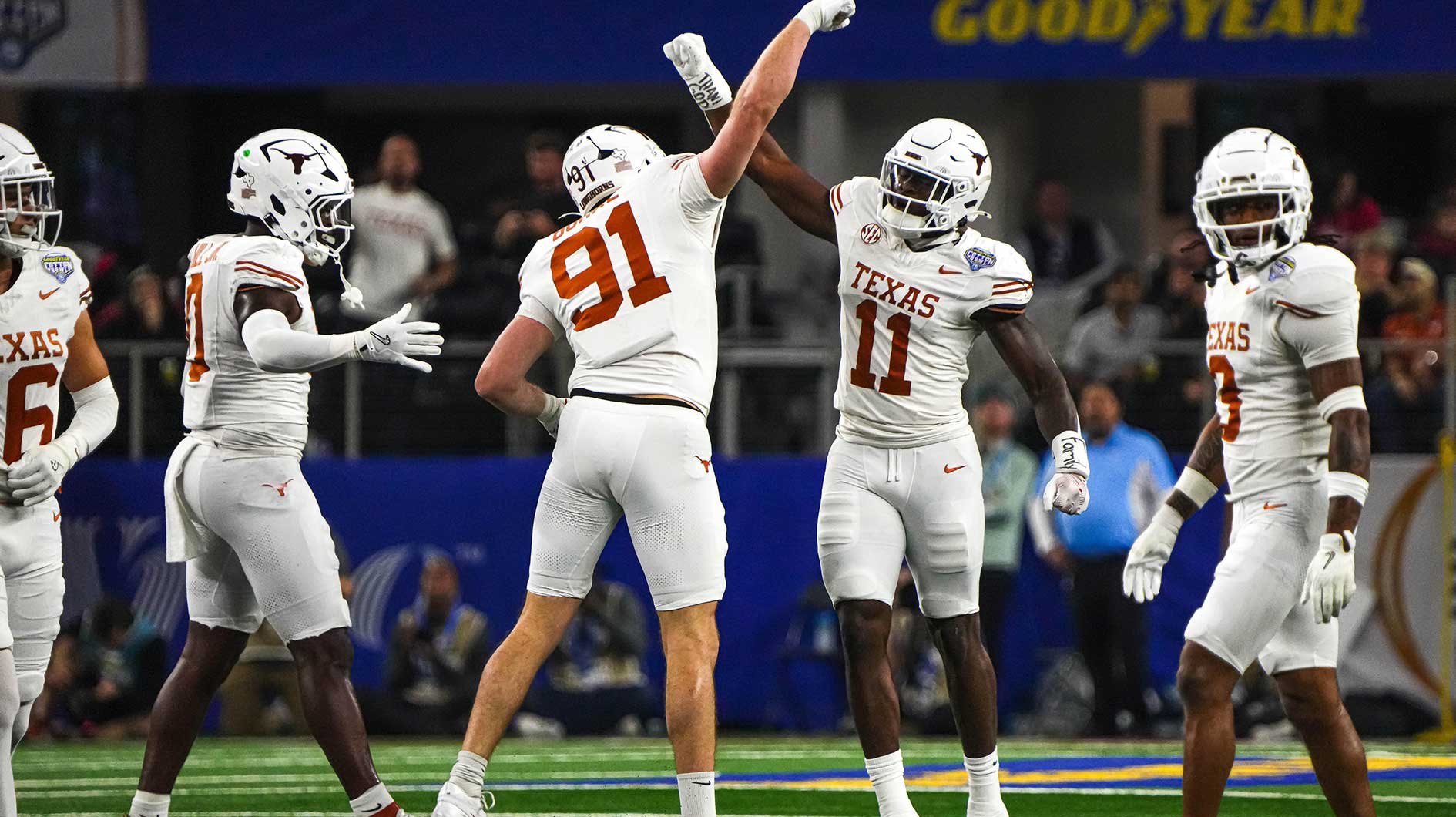 Texas Longhorns edge rushers Colin Simmons (11) and Ethan Burke (91) celebrate a sack during the College Football Playoff semifinal game against Ohio State in the Cotton Bowl at AT&T Stadium on Friday, Jan. 10, 2024 in Arlington, Texas.