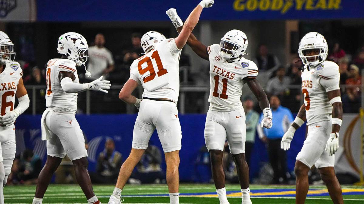 Texas Longhorns edge rushers Colin Simmons (11) and Ethan Burke (91) celebrate a sack during the College Football Playoff semifinal game against Ohio State in the Cotton Bowl at AT&T Stadium on Friday, Jan. 10, 2024 in Arlington, Texas.