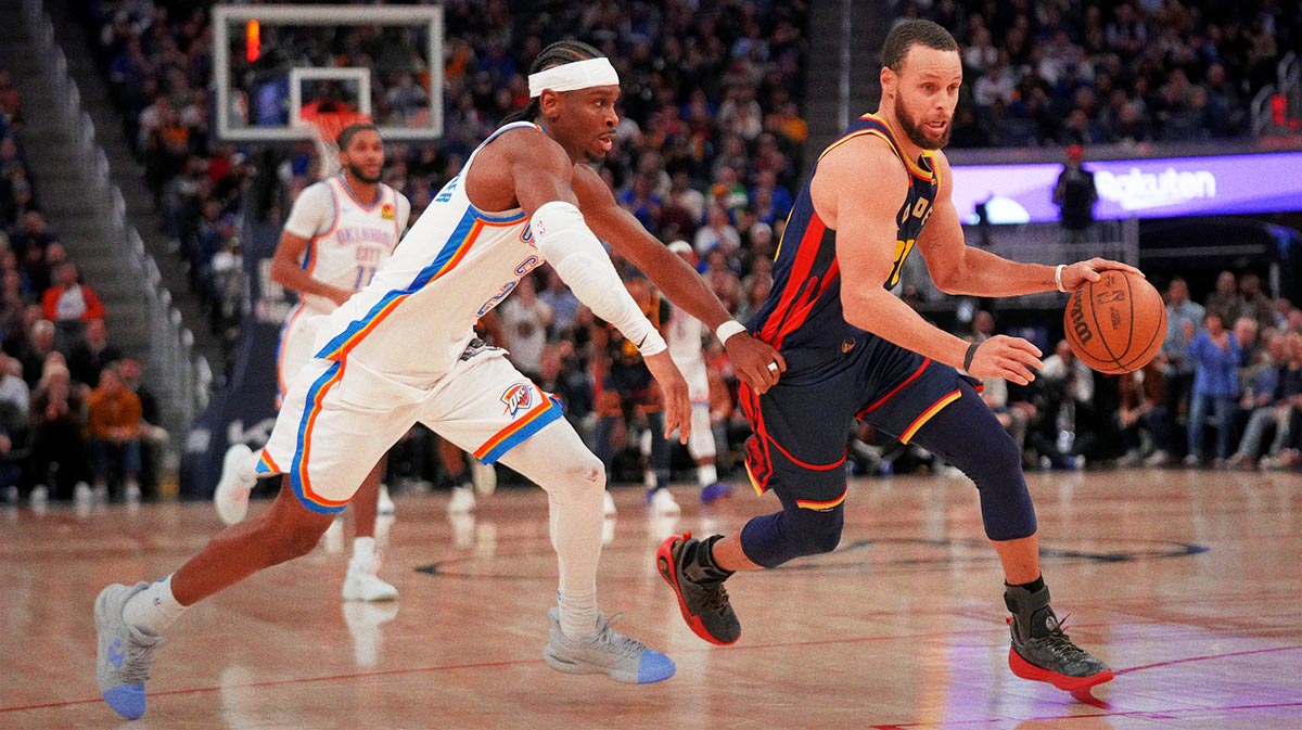 Warriors guard Stephen Curry (30) dribbles past Oklahoma City Thunder guard Shai Gilgeous-Alexander (2) in the third quarter at the Chase Center with Richard Jefferson in the background