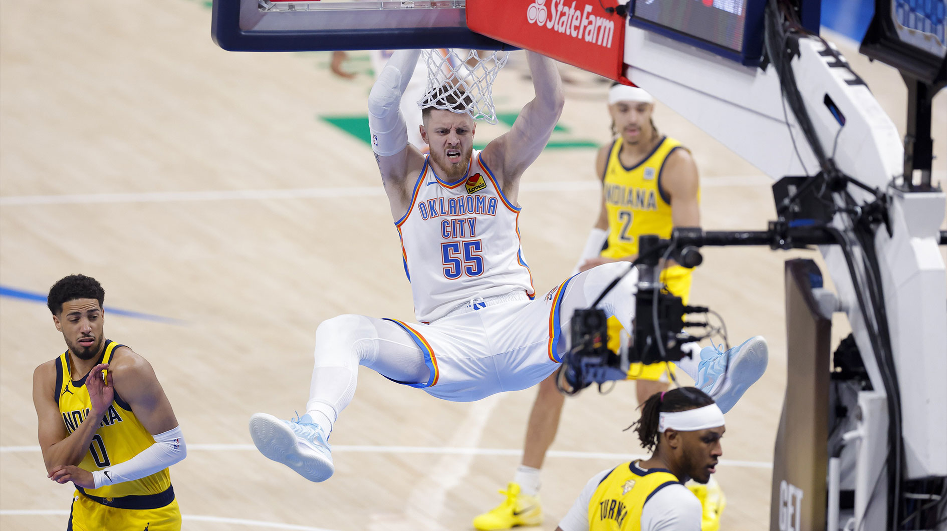 Thunder center Isaiah Hartenstein (55) dunks the ball as Indiana Pacers guard Tyrese Haliburton (0) looks on in the first quarter during game five of the 2025 NBA Finals at Paycom Center