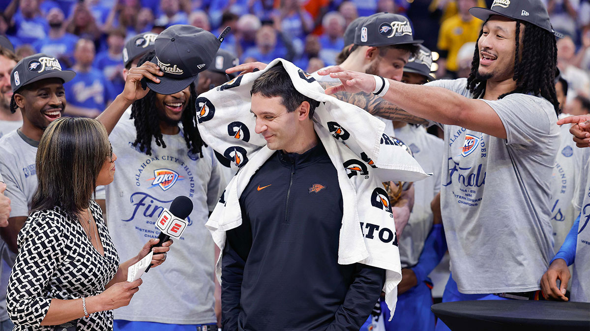 Thunder team members place towels on Thunder head coach Mark Daigneault during an interview after their team won the western conference finals for the 2025 NBA Playoffs at Paycom Center