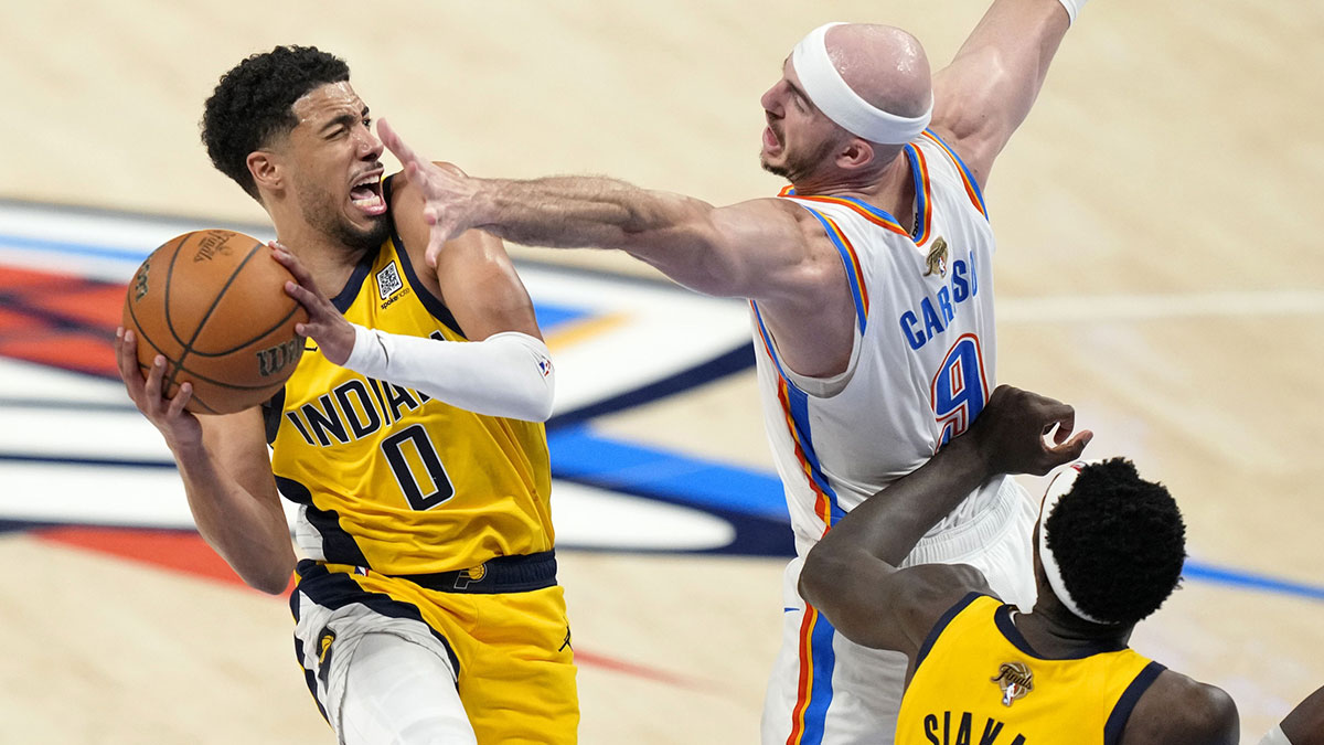 Indiana Pacers guard Tyrese Haliburton (0) drives to the basket against Oklahoma City Thunder guard Alex Caruso (9) during the fourth quarter in game one of the 2025 NBA Finals at Paycom Center.