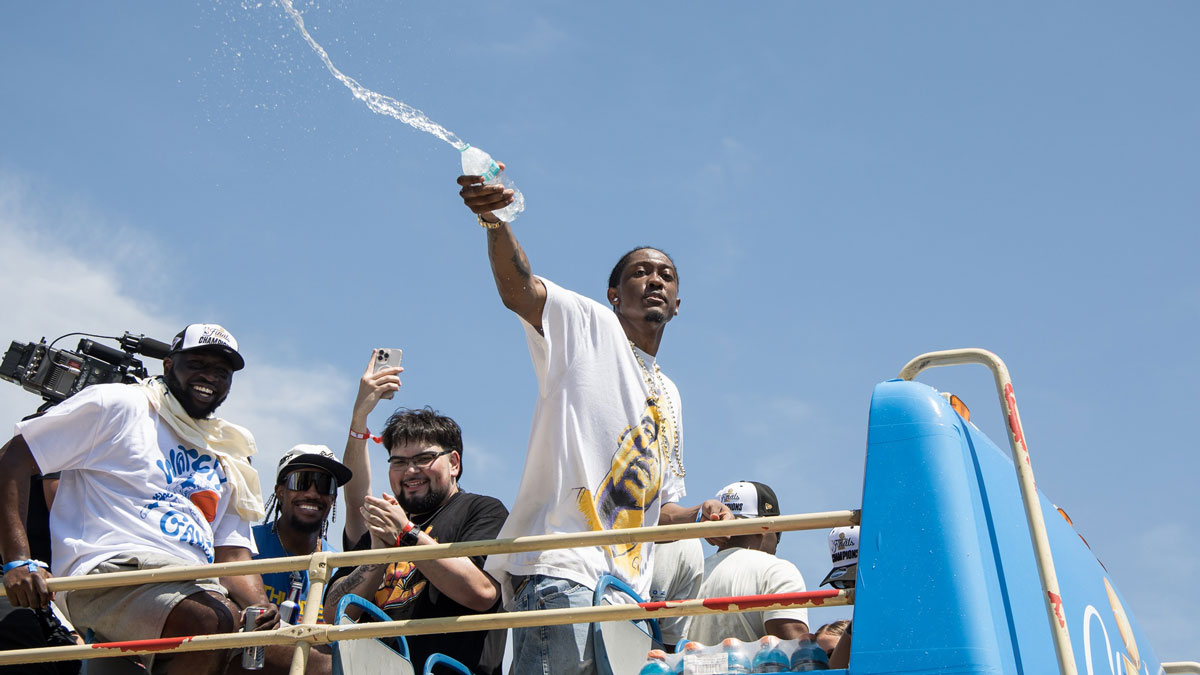 Oklahoma City Thunder player Jalen Williams splashes water on fans during the 2025 NBA Oklahoma City Thunder championship parade.