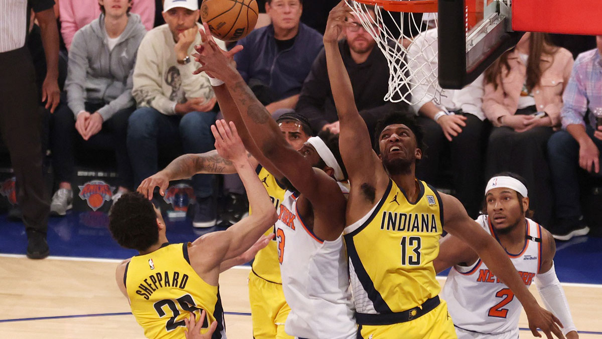 New York Knicks center Mitchell Robinson (23) reaches for the rebound against Indiana Pacers guard Ben Sheppard (26) and center Tony Bradley (13) in the first quarter during game five of the eastern conference finals for the 2025 NBA Playoffs at Madison Square Garden.