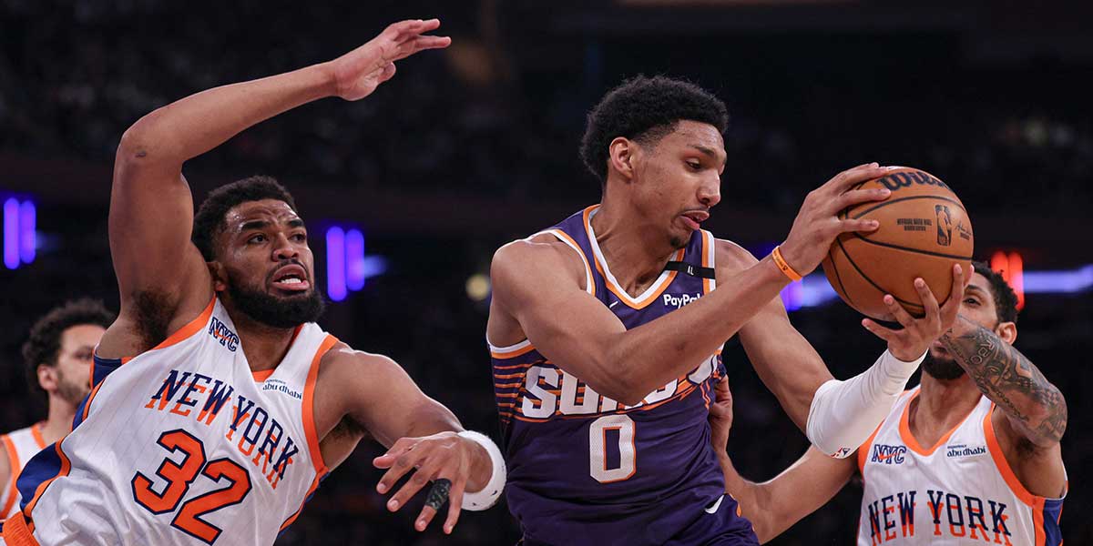 Phoenix Suns forward Ryan Dunn (0) rebounds against New York Knicks center Karl-Anthony Towns (32) and guard Cameron Payne (1) during the first half at Madison Square Garden.