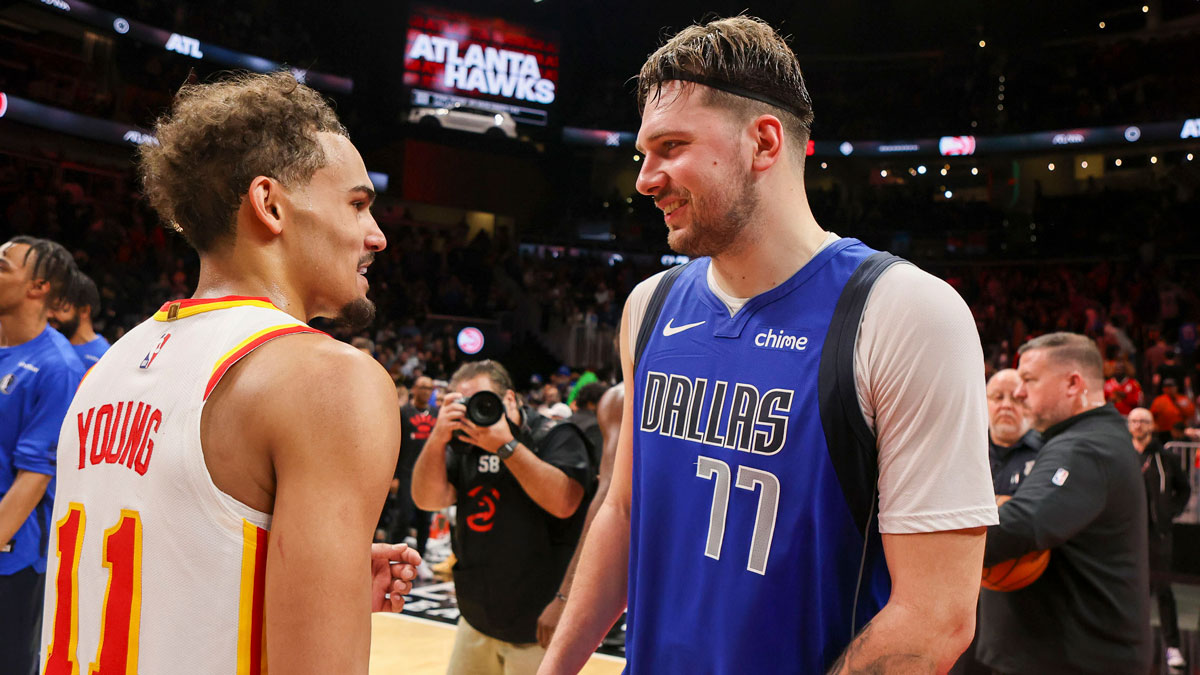 Atlanta Hawks guard Trae Young (11) talks to Dallas Mavericks guard Luka Doncic (77) after a game at State Farm Arena.