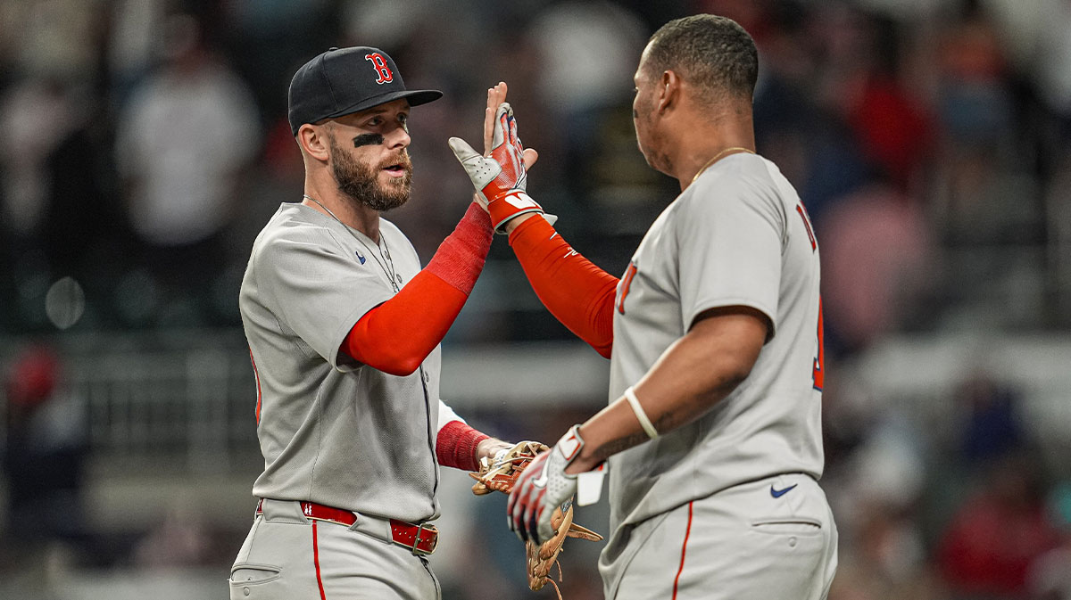 Boston Red Sox shortstop Trevor Story (10) and designated hitter Rafael Devers (11) react after the Red Sox defeated the Atlanta Braves at Truist Park.