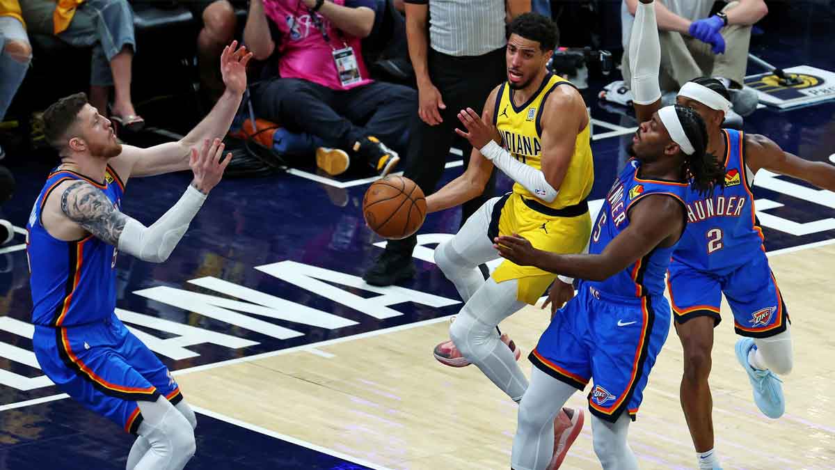 Indiana Pacers guard Tyrese Haliburton (0) passes the ball against Oklahoma City Thunder guard Luguentz Dort (5) during the fourth quarter in game three of the 2025 NBA Finals at Gainbridge Fieldhouse.