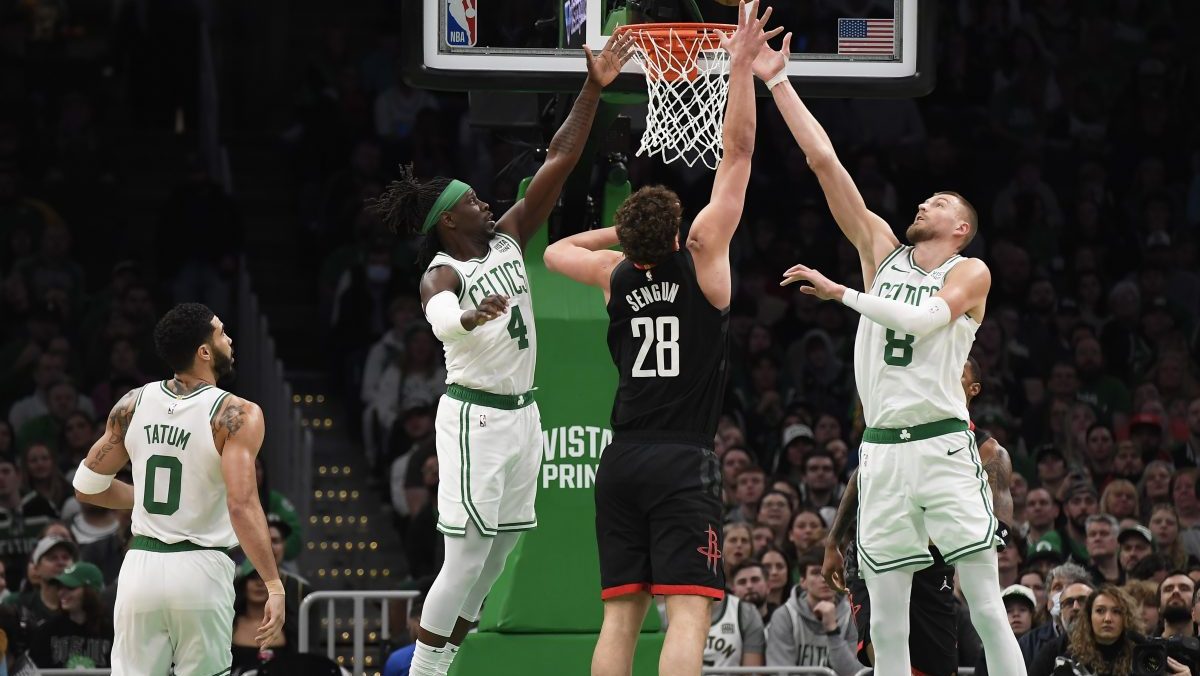 Boston Celtics guard Jrue Holiday (4) and center Kristaps Porzingis (8) and Houston Rockets center Alperen Sengun (28) battle for a rebound during the first half at TD Garden.