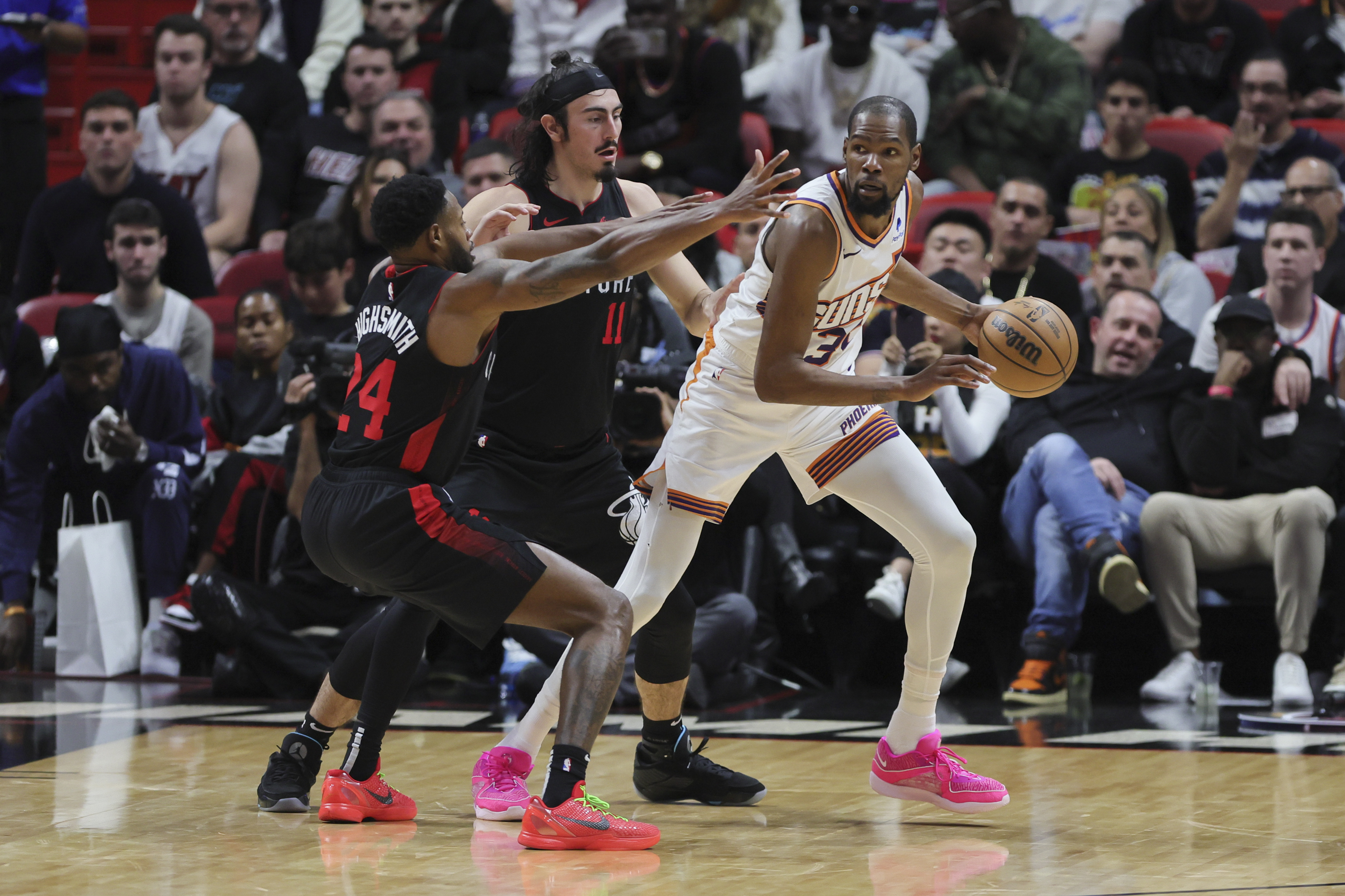 Phoenix Suns forward Kevin Durant (35) protects the basketball from Miami Heat forward Haywood Highsmith (24) and guard Jaime Jaquez Jr. (11) during the third quarter at Kaseya Center.