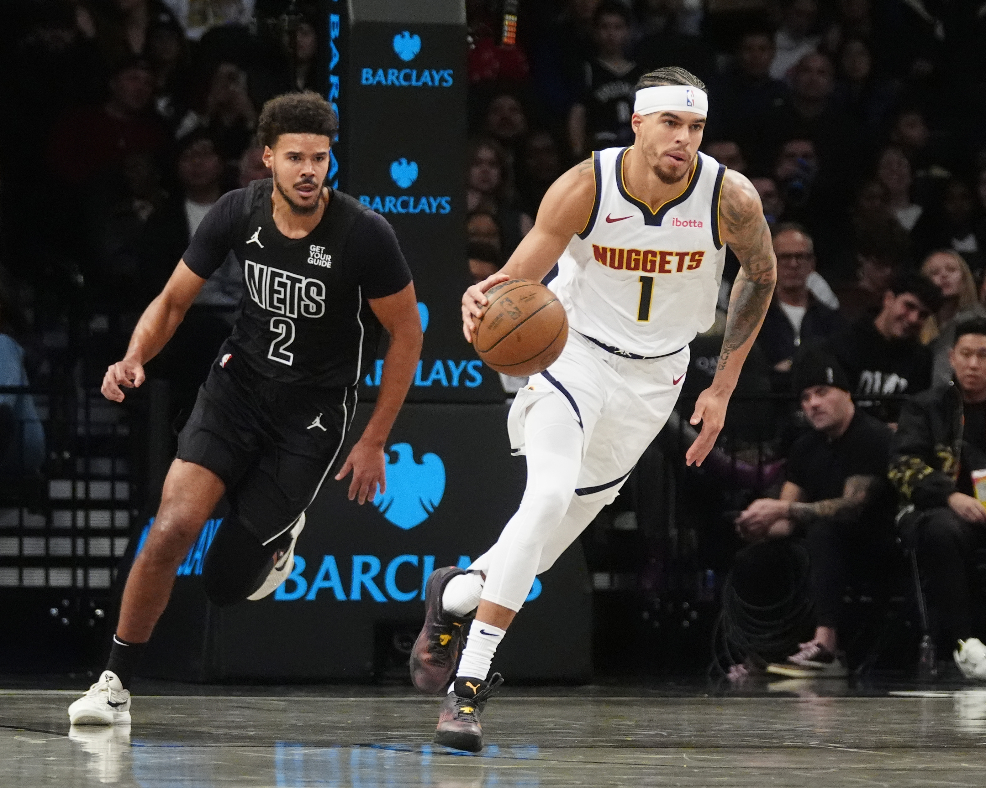 Denver Nuggets small forward Michael Porter Jr. (1) dribbles the ball up the court past Brooklyn Nets small forward Cameron Johnson (2) during the first half at Barclays Center.