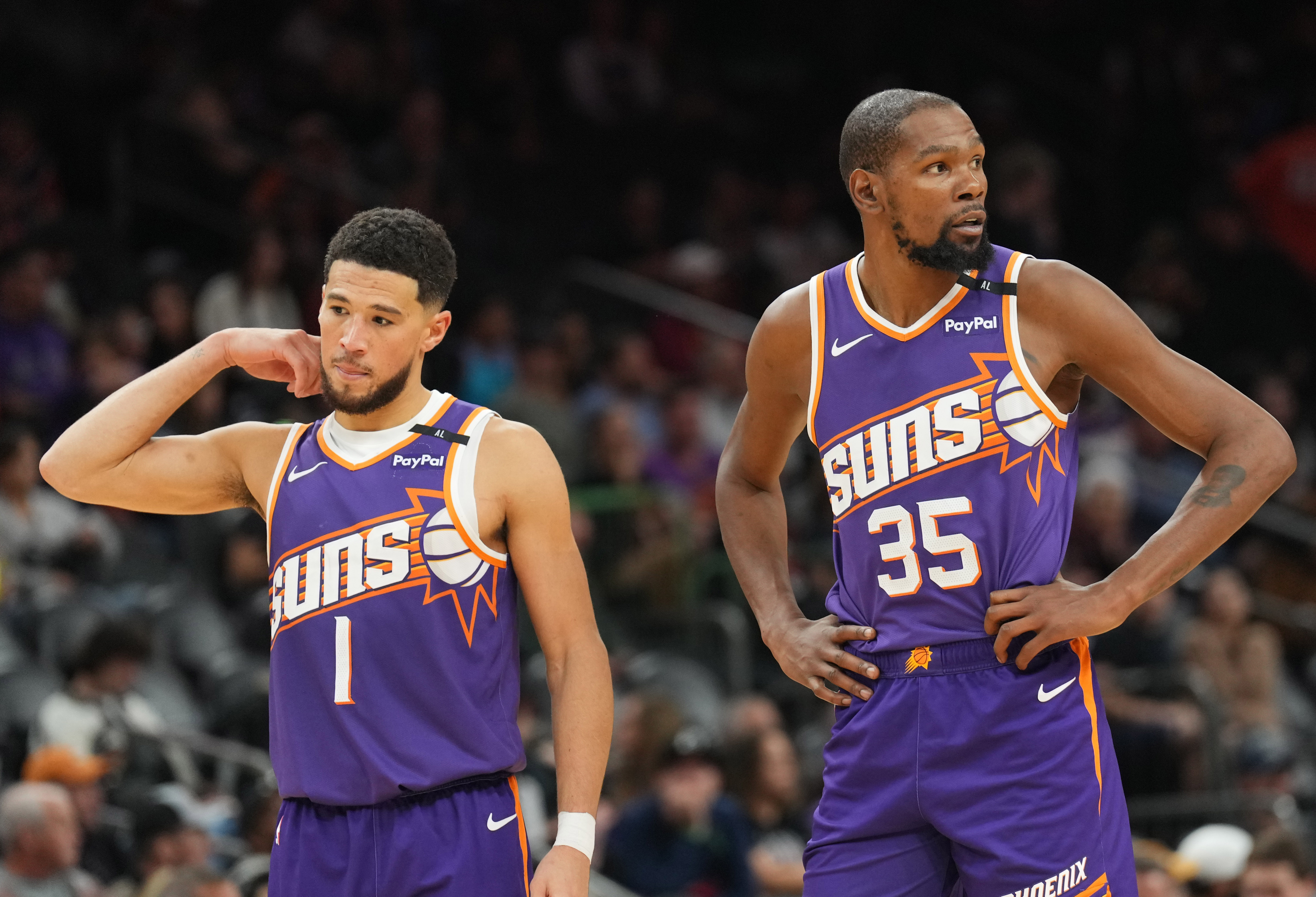 Phoenix Suns guard Devin Booker (1) and Phoenix Suns forward Kevin Durant (35) look on against the Brooklyn Nets during the second half at Footprint Center.