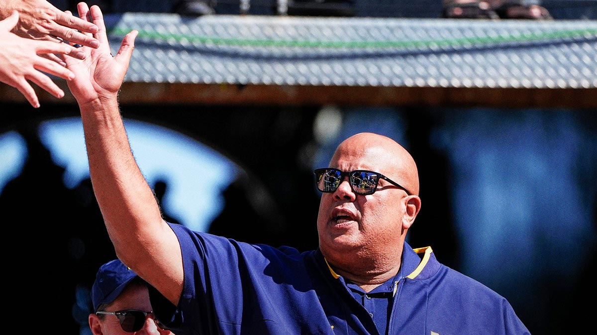 Michigan athletic director Warde Manuel high-fives fans as he walks down the tunnel for warm up before the USC game at Michigan Stadium