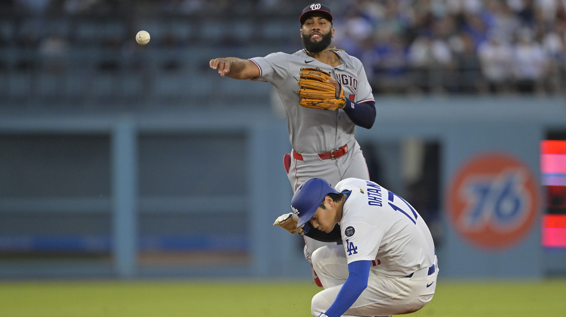 Los Angeles Dodgers two-way player Shohei Ohtani (17) ducks as Washington Nationals third base Amed Rosario (13) tries for a triple play against a ball hit by shortstop Mookie Betts (50) during the third inning at Dodger Stadium.