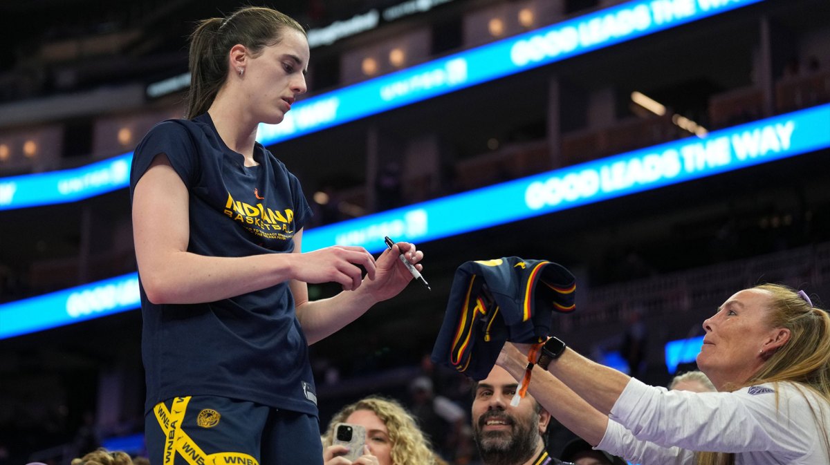 ndiana Fever guard Caitlin Clark (left) signs an autograph before the game against the Golden State Valkyries at Chase Center.