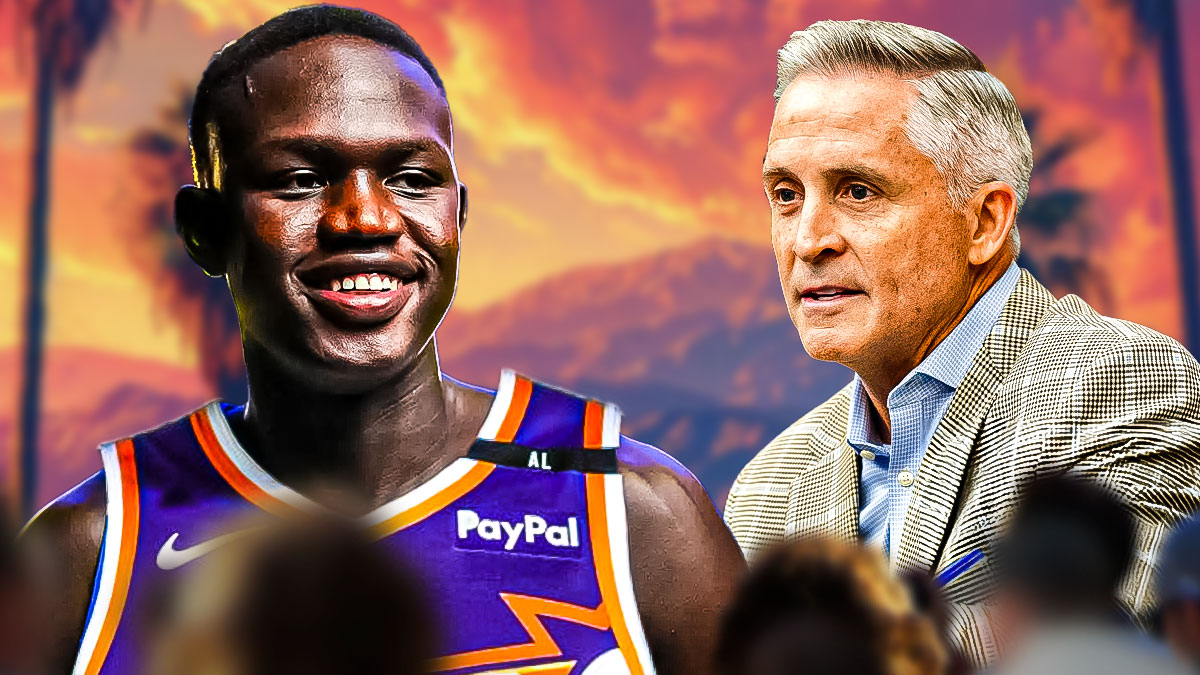 Khaman Maluach in a Suns jersey smiling with general manager Brian Gregory smiling next to him.