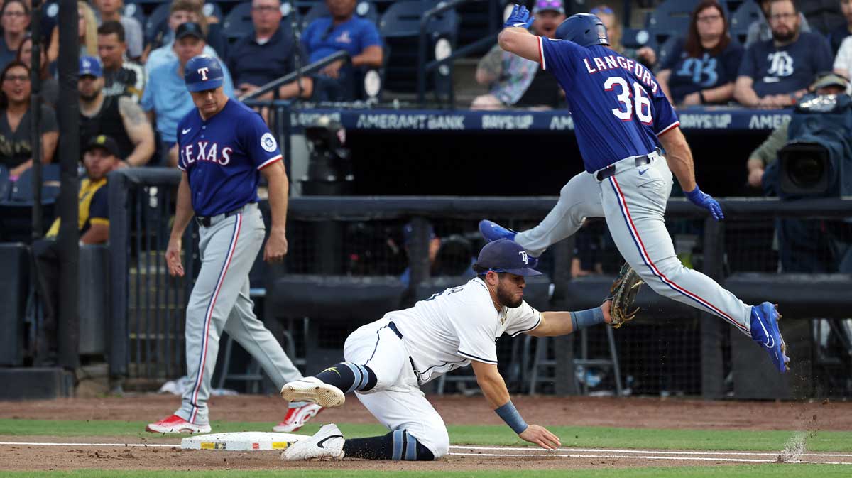 Jun 4, 2025; St. Petersburg, Florida, USA; Texas Rangers outfielder Wyatt Langford (36) jumps over Tampa Bay Rays first base Jonathan Aranda (62) as he jumps over as he is safe at fires base during the first inning at George M. Steinbrenner Field.