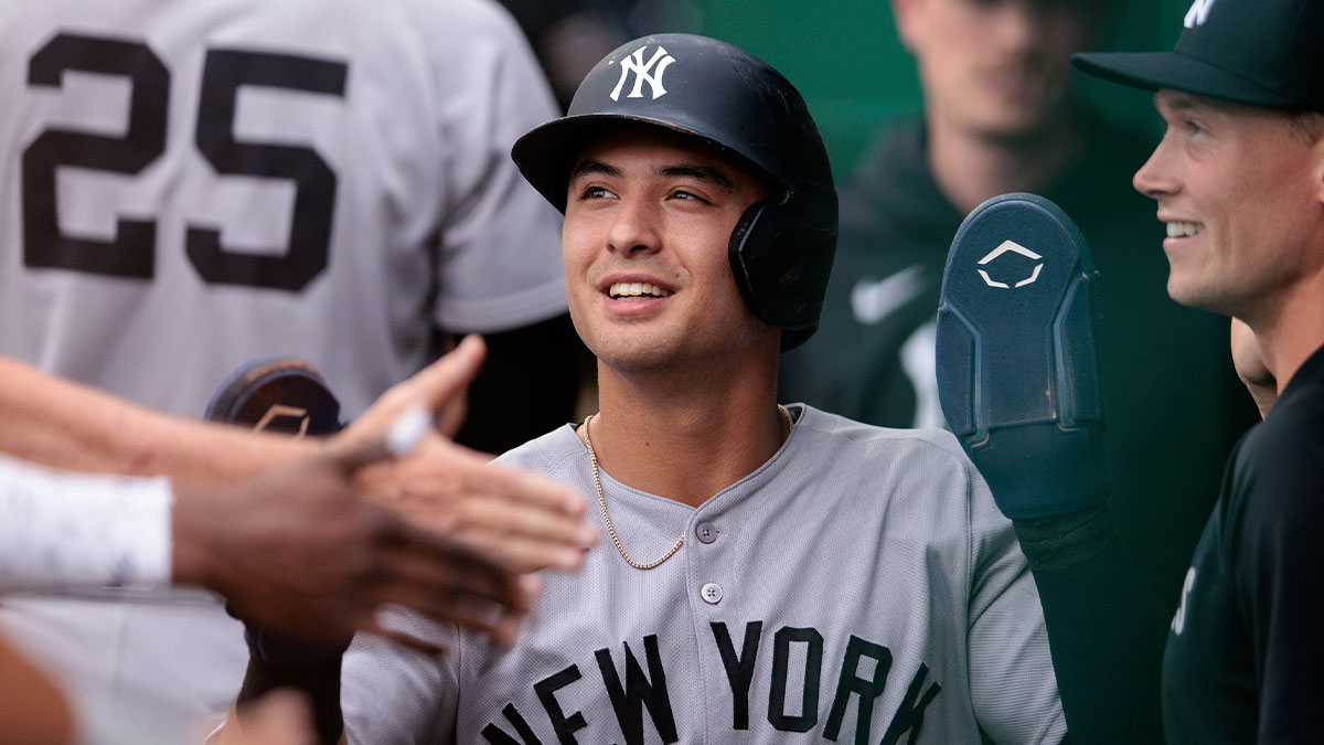 New York Yankees shortstop Anthony Volpe (11) celebrates in the dugout after scoring during the second inning against the Kansas City Royals at Kauffman Stadium.