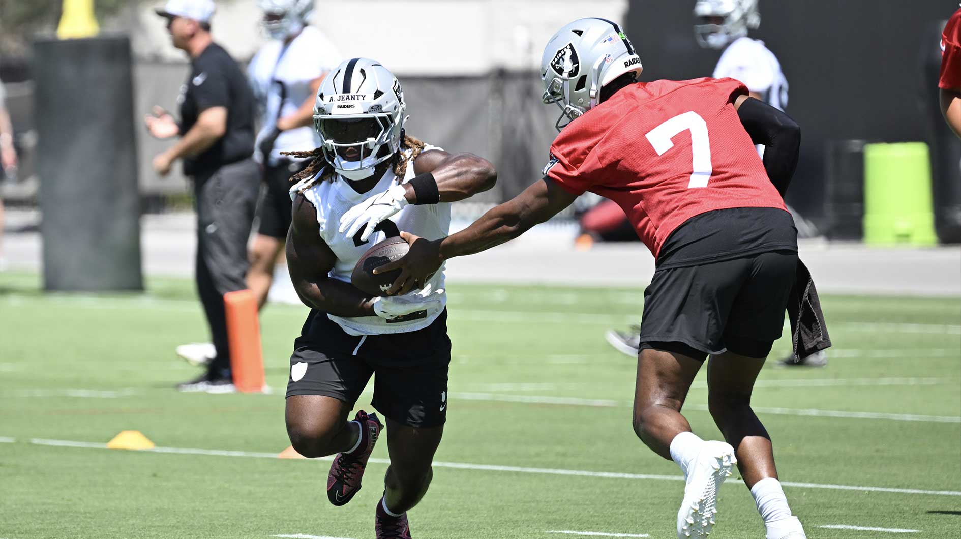 Las Vegas Raiders quarterback Geno Smith (7) hands the ball off to running back Ashton Jeanty (2) during Las Vegas Raiders Minicamp at Intermountain Health Performance Center.