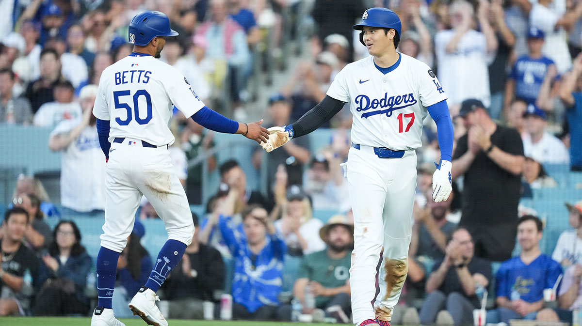 Los Angeles Dodgers designated hitter Shohei Ohtani (17) celebrates with Los Angeles Dodgers shortstop Mookie Betts (50) after scoring a run during the third inning against the Chicago White Sox at Dodger Stadium.