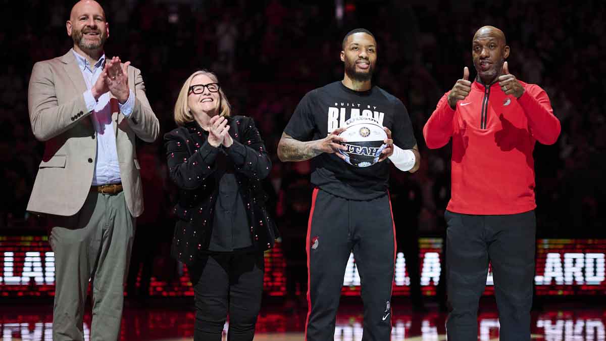 Blazers GM Joe Cronin, left, owner Jody Allen, and head coach Chauncey Billups stand with guard Damian Lillard