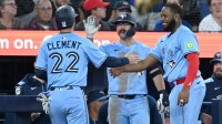 Toronto Blue Jays third baseman Ernie Clement (22) is greeted by left fielder Davis Schneider (36) and Vladimir Guerrero Jr. (27, right) after scoring a run against the New York Yankees in the sixth inning at Rogers Centre