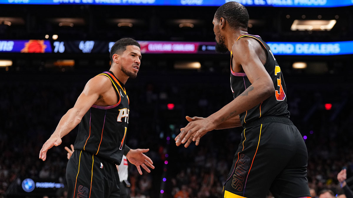 Phoenix Suns guard Devin Booker (1) and Phoenix Suns forward Kevin Durant (35) slap hands against the Cleveland Cavaliers during the second half at Footprint Center.