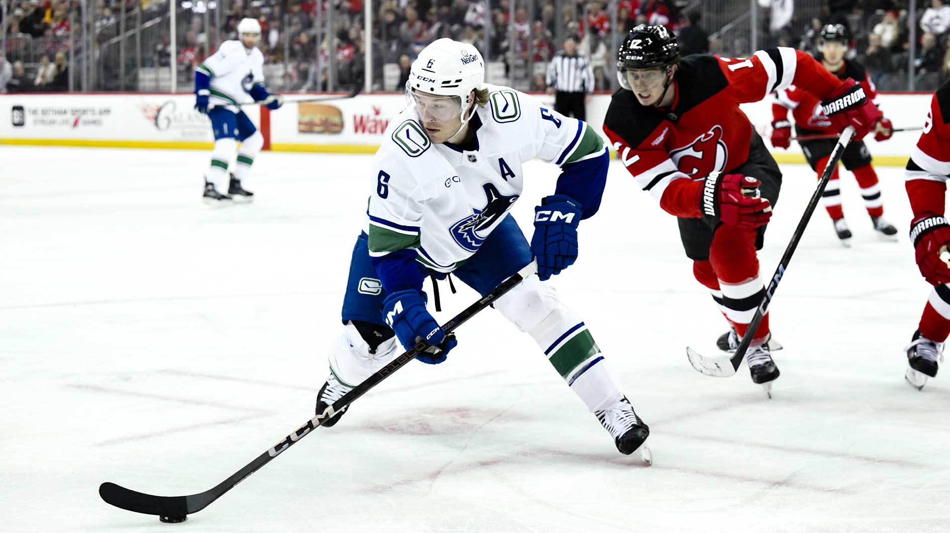 Vancouver Canucks right wing Brock Boeser (6) controls the puck as New Jersey Devils defenseman Simon Nemec (17) defends during the third period at Prudential Center.