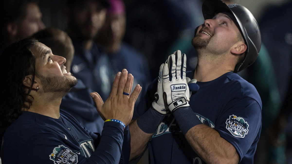 Seattle Mariners catcher Cal Raleigh (29), right, celebrates in the dugout with third baseman Eugenio Suarez (28) after hitting a solo home run during the second inning against the Milwaukee Brewers at T-Mobile Park.