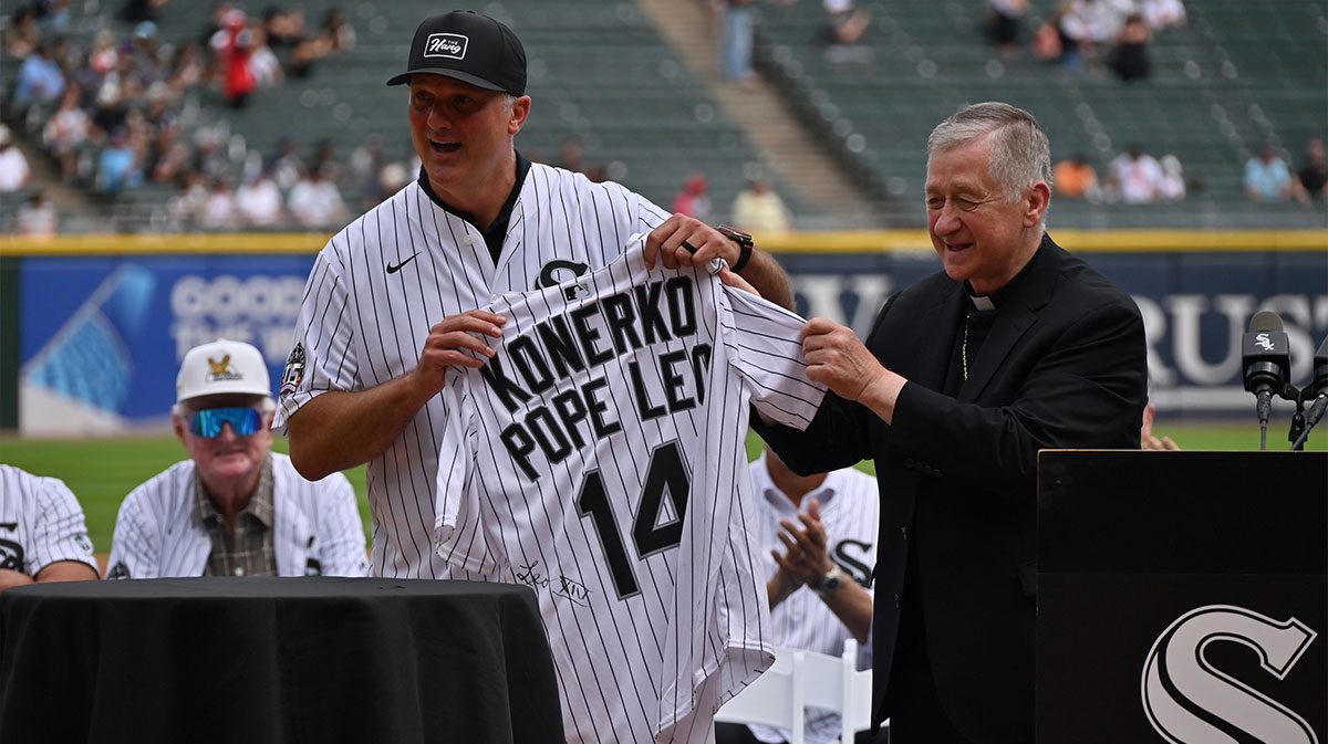 Cardinal Blase Cupich, Archbishop of Chicago, presents Paul Konerko, member of the 2005 World Series Chicago White Sox, with a jersey signed by Pope Leo XIV prior to a game against the Cleveland Guardians at Rate Field.