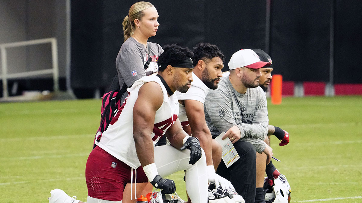 Arizona Cardinals players take a knee after linebacker J.J. Russell (51) suffered a head and neck injury during training camp