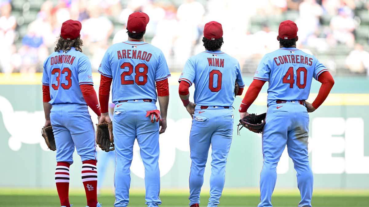 St. Louis Cardinals second baseman Brendan Donovan (33) and third baseman Nolan Arenado (28) and shortstop Masyn Winn (0) and first baseman Willson Contreras (40) check the replay of Texas Rangers center fielder Wyatt Langford (not pictured) being called out at first base during the ninth inning at Globe Life Field.