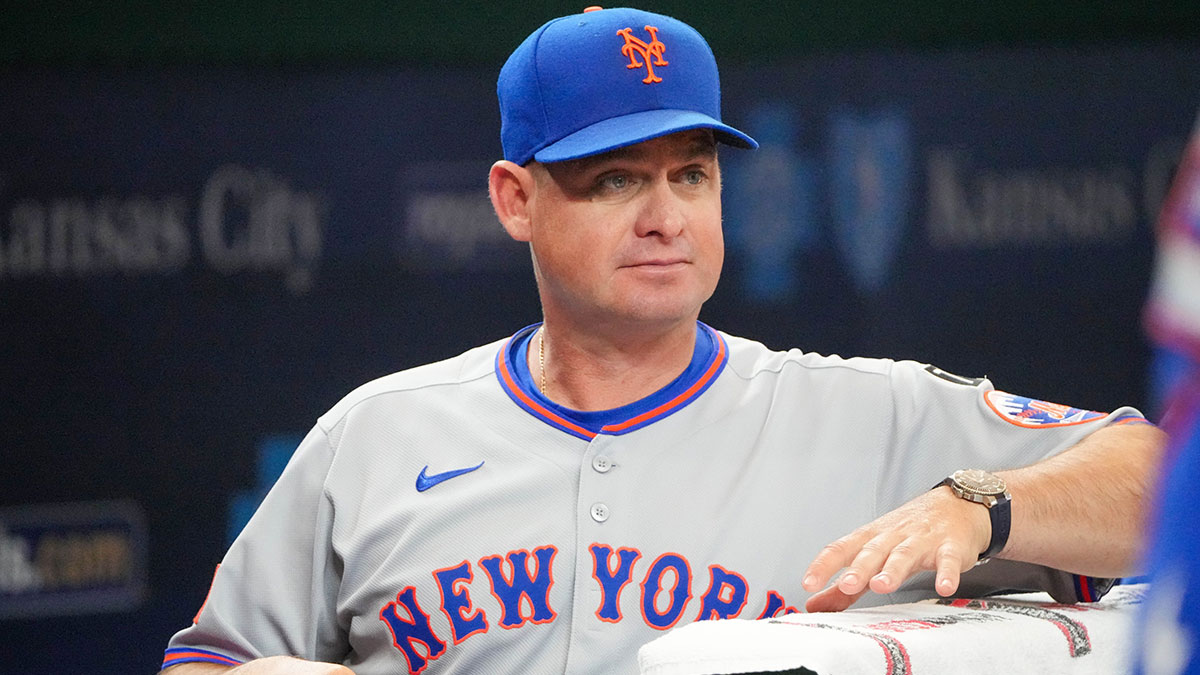 New York Mets manager Carlos Mendoza (64) watches from the dugout against the Kansas City Royals prior to a game at Kauffman Stadium.