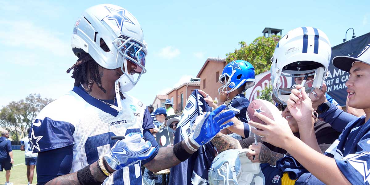 Dallas Cowboys receiver CeeDee Lamb (88) signs autographs during training camp at the River Ridge Fields.