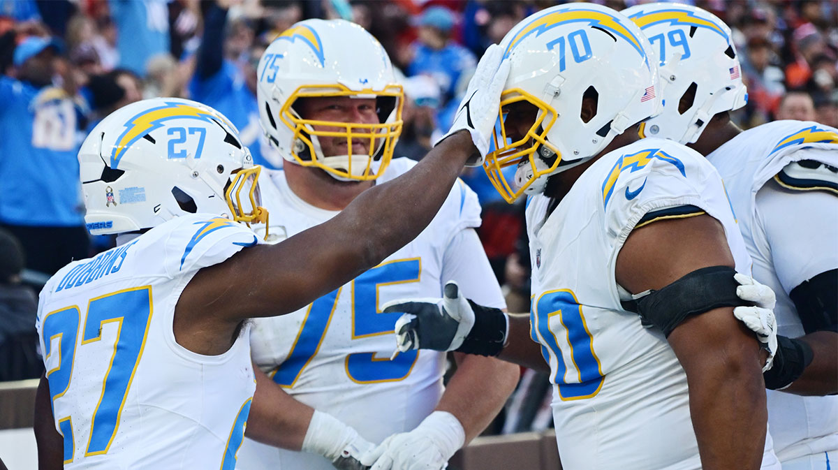 Los Angeles Chargers running back J.K. Dobbins (27) celebrates with offensive tackle Rashawn Slater (70) after scoring a touchdown during the first half against the Cleveland Browns at Huntington Bank Field.