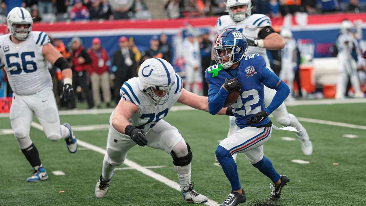 New York Giants cornerback Dru Phillips (22) returns an interception as Indianapolis Colts offensive tackle Bernhard Raimann (79) tackles during the second half at MetLife Stadium.