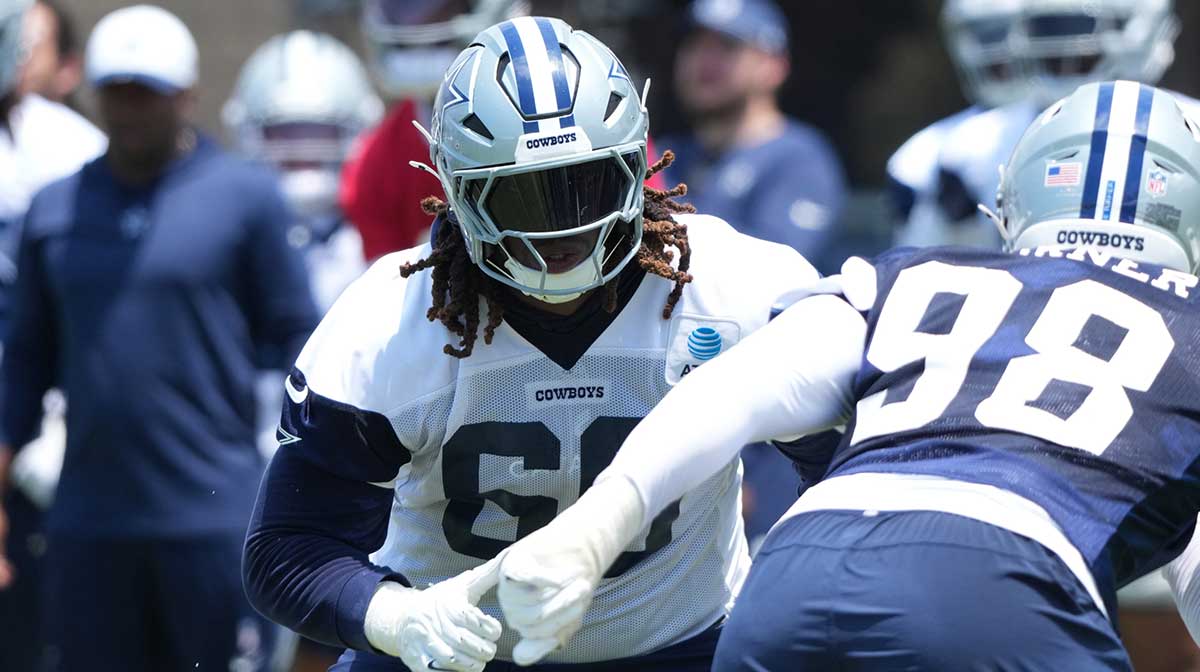 Dallas Cowboys tackle Tyler Guyton (60) defends against defensive end Payton Turner (98) during training camp at the River Ridge Fields.