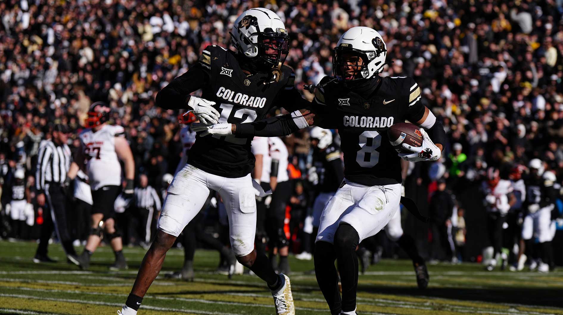 Colorado Buffaloes cornerback DJ McKinney (8) celebrates his interception with wide receiver Travis Hunter (12) in the second half against the Oklahoma State Cowboys at Folsom Field.
