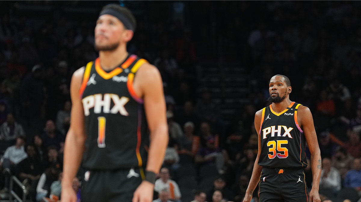 Phoenix Suns guard Devin Booker (1) and Phoenix Suns forward Kevin Durant (35) look on against the Memphis Grizzlies during the first half at Footprint Center.
