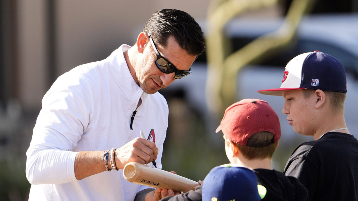 Arizona Diamondbacks Executive Vice President and General Manager Mike Hazen signs his autograph during spring training practice at Salt River Fields at Talking Stick on Feb. 12, 2025, in Scottsdale.