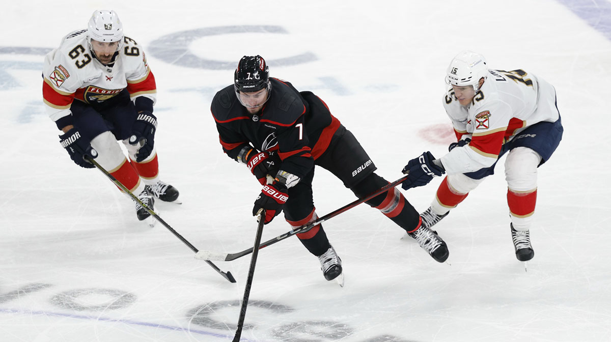Carolina Hurricanes defenseman Dmitry Orlov (7) skates with the puck as Florida Panthers center Brad Marchand (63) and Panthers center Anton Lundell (15) defend in game five of the Eastern Conference Final of the 2025 Stanley Cup Playoffs at Lenovo Center.