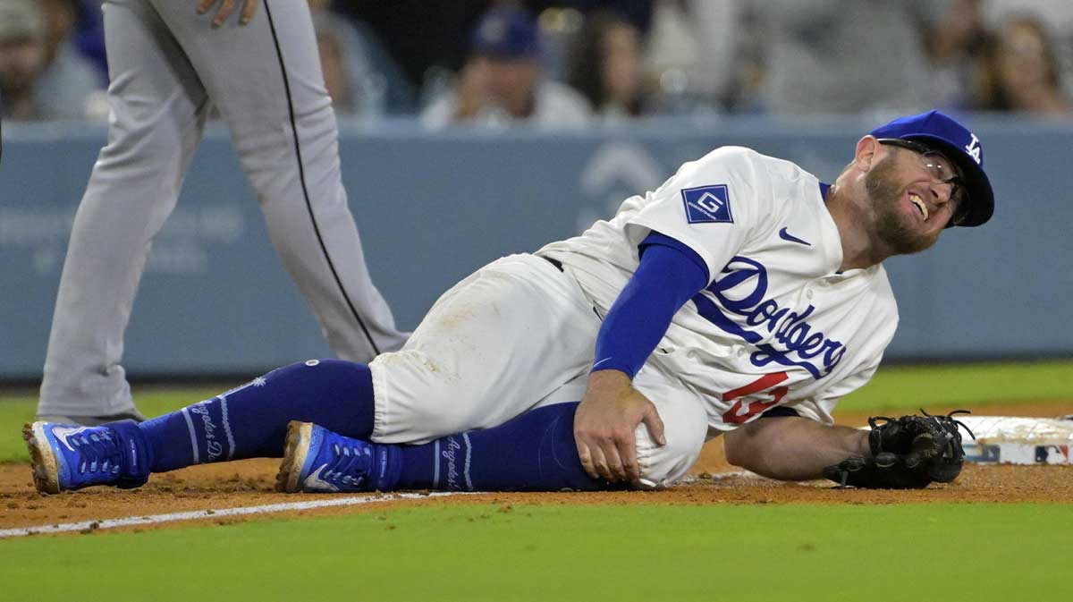 Los Angeles Dodgers third baseman Max Muncy (13) grabs his knee after tagging Chicago White Sox right fielder Michael A. Taylor (21) out on an attempted stolen base during the fifth inning at Dodger Stadium.