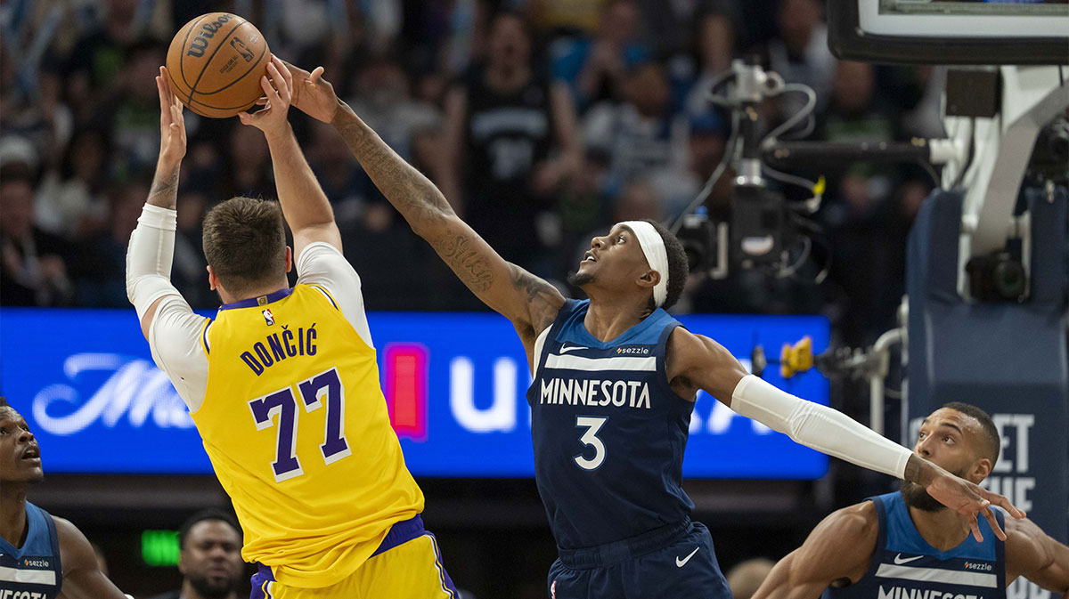 Los Angeles Lakers guard Luka Doncic (77) shoots the ball over Minnesota Timberwolves forward Jaden McDaniels (3) in the second half during game three of first round for the 2024 NBA Playoffs at Target Center.