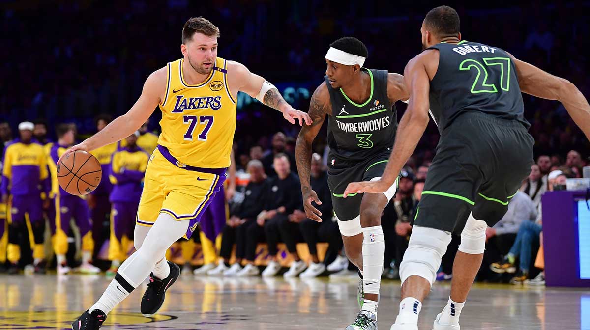 Los Angeles Lakers guard Luka Doncic (77) moves the ball against Minnesota Timberwolves forward Jaden McDaniels (3) and center Rudy Gobert (27) during the first half in game five of first round for the 2025 NBA Playoffs at Crypto.com Arena.